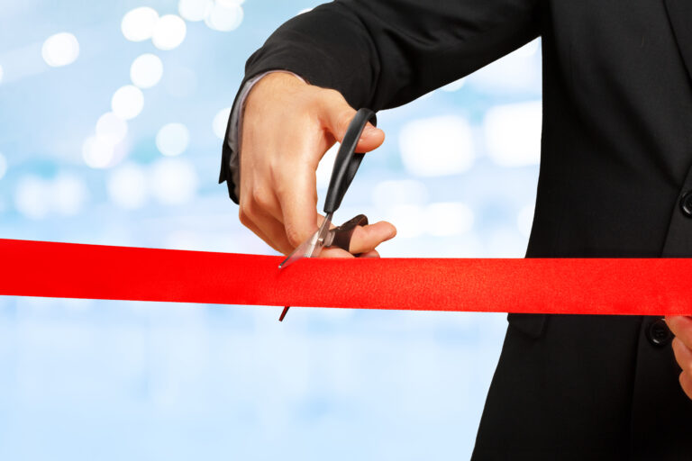 Ribbon cutting ceremony celebrating a local business opening.
