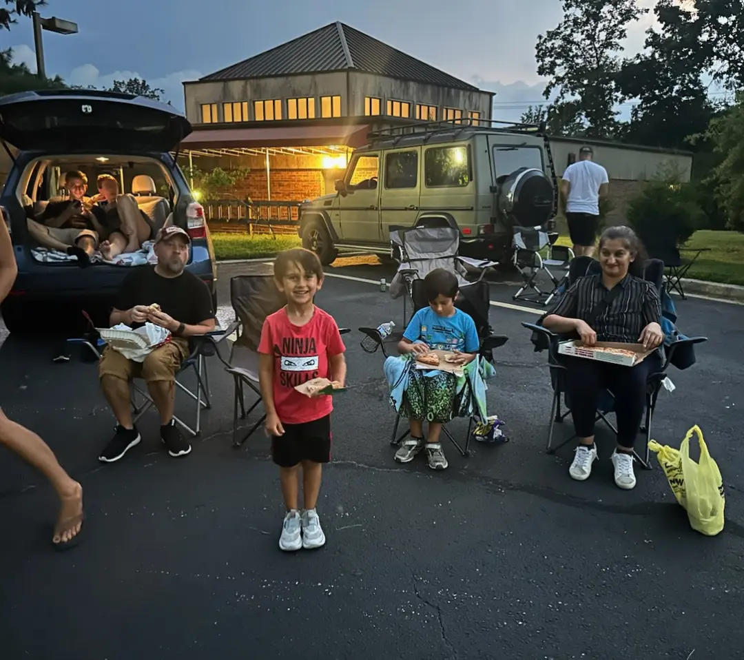Families gathering for a SOFO community event at dusk.