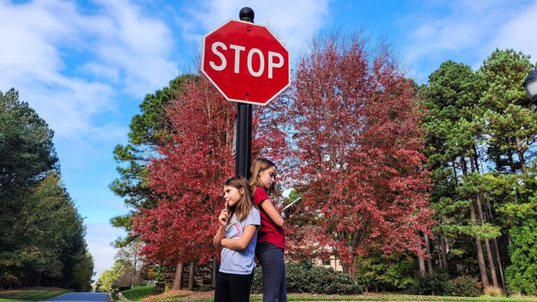 girls-standing-near-a-stop-sign-on-street-2026-03-18-17-44-24-utc